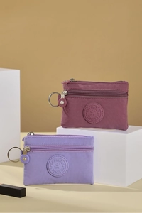 Detail of mini nylon coin purses with double zippers and metal keyrings in purple and pink