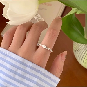 Detailed view of silver chain ring with square clear crystal worn by a female model