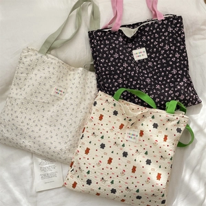 Detail shot of bubble textured fabric tote bags with floral and bear patterns on white bedding