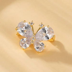 Detailed close-up of golden butterfly brooch featuring pear-cut cubic zirconia wings