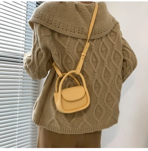 Mini sac à bandoulière jaune porté avec un pull en maille beige pour un style élégant