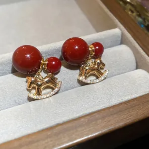 18K gold plated rocking horse earrings with red beads and sparkling cubic zirconia