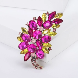 Detail of vintage flower brooch with large rose red and yellow faceted crystals in bronze setting
