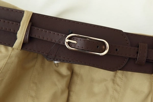 Gros plan détaillé de la ceinture en cuir PU marron foncé avec boucle ovale dorée