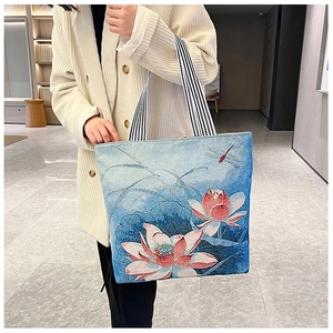 Detail of floral embroidery with lotus and dragonfly pattern on blue tote bag