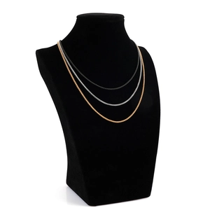 Tre catene in acciaio al titanio color oro, argento e nero esposte su un modello a collo