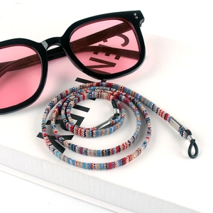 Detail of colorful bohemian braided eyewear strap with silver metal and black silicone loops