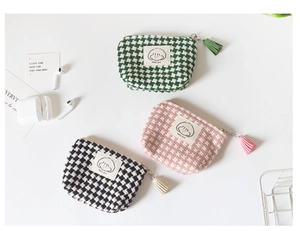 Detail of mini plaid coin purses with fringe zippers and cute cartoon girl labels