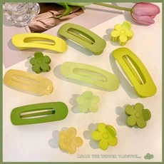 Close-up of matte green rectangle hair clips and flower hair claws set for girls
