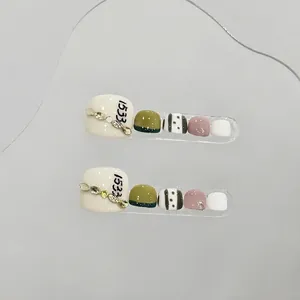 Handmade emerald and cream pedicure press-on nails with rhinestone leaf accents