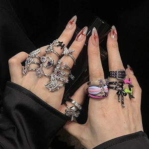 Detail shot of punk Y2K style butterfly and star rings with zircon and enamel inlays
