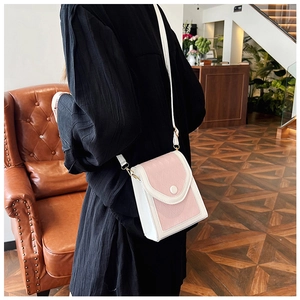 Détail arrière d'un mini sac bandoulière matelassé rose et blanc porté par un mannequin
