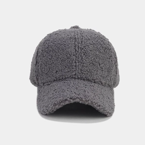 Detailed texture of thick dark grey faux shearling fabric on a warm baseball cap
