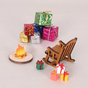 Miniature Christmas decor set with wooden rocking chair, campfire, and colorful gift boxes