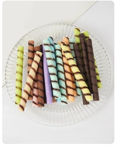 Close-up of assorted macaron colored PVC chocolate sticks on a glass plate