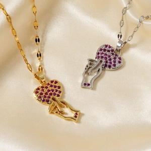 Gold and silver heart pendant necklaces with purple zircons on beige silk background