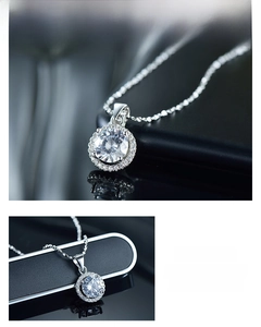 Detail showing the classic round-cut center stone and halo setting on a silver necklace