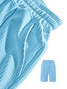Detail of light blue waffle knit fabric and elastic drawstring waistband on men's shorts