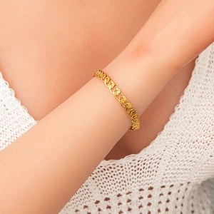 Close-up of 18K gold plated evil eye bracelet featuring geometric chain links on wrist