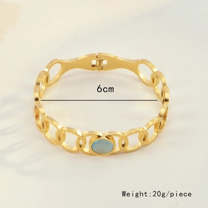 Detail shot of golden stainless steel bracelet featuring green cat-eye stone and 6cm diameter