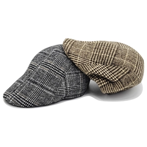 Detailed view of winter wool blend newsboy caps with classic grey and brown plaid patterns
