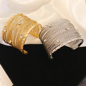Detail of wide multi-layer braided cuff bracelet with sparkling rhinestones in gold and silver