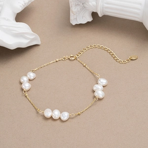 Bracelet élégant en argent S925 doré avec perles naturelles sur fond minimaliste chic