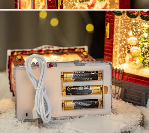 Detail of Christmas house lantern showing dual power options via USB cable or 3 AA batteries