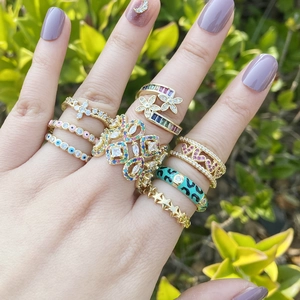 Detailed view of fashion rings featuring evil eye and star motifs worn on model hand