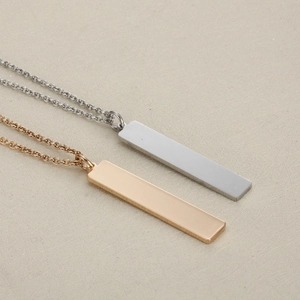 Macro shot of polished silver and gold rectangular pendants on fine cross chains