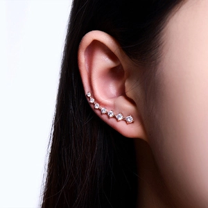 Close-up of rose gold ear crawler with seven sparkling white zircons on a model