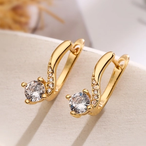 Elegant gold-plated copper leaf earrings with zircon crystals shown in a pair on beige base
