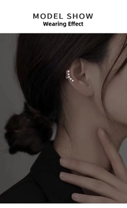 Detailed view of model wearing elegant pearl ear cuff with silver base on ear cartilage