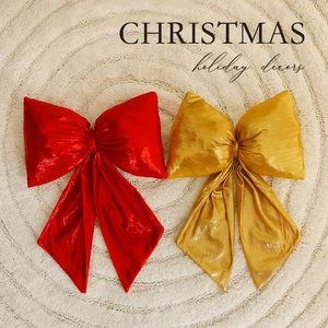 Red and gold velvet Christmas tree bows on a soft white plush rug for holiday decor