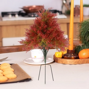Detailed view of mini pine needle Christmas tree with red-green gradient on black stand