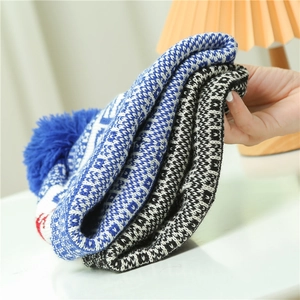 Close-up of thick knit Christmas hats with geometric patterns and soft pom-pom details