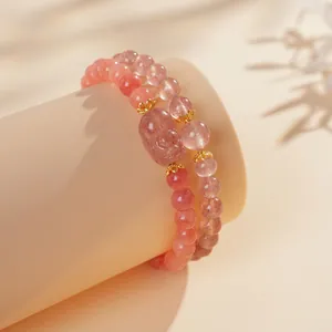Bracciale a doppio strato in quarzo fragola rosa con ciondoli dorati su espositore