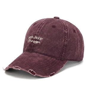 Dettaglio cappello baseball in cotone lavato con ricamo bianco e bordo sfrangiato vintage