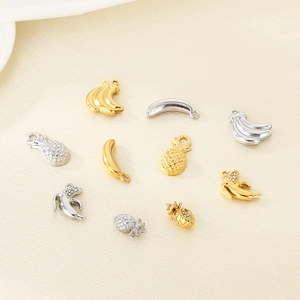Macro detail of hollow banana and pineapple pendants with small rhinestone accents