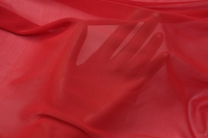 Gros plan sur le tissu en maille rouge transparent montrant sa texture fine