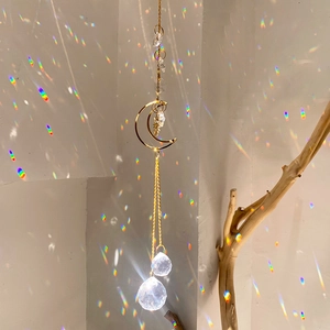 Detailed view of moon and star suncatcher with crystal prisms reflecting rainbow light