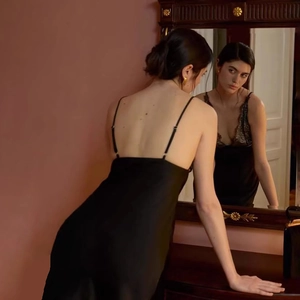 Elegantes schwarzes Satin-Slipkleid mit feiner Spitze in einer Vintage-Spiegelreflexion