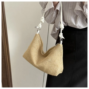 Détail du sac bandoulière en paille tissée avec bandoulière à nœud en corde blanche
