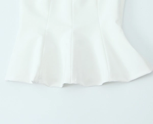 Detail of white stretch top showing the ruffle hem design and smooth fabric texture