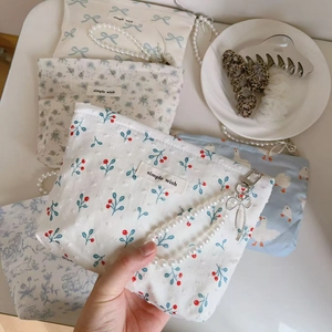 Detail of floral cotton mini bags with pearl chains and textured polka dot fabric