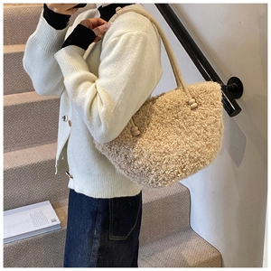 Détail du cabas en peluche beige avec bretelles en cuir et perles décoratives élégantes
