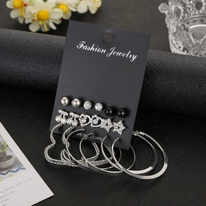 Detail of earring set featuring metal hoops, rhinestone hearts, stars and studs on display