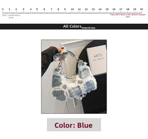 Detail of blue denim shoulder bag with white fringe and acrylic chain decoration