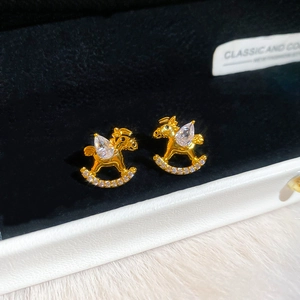 Detailed close-up of gold-plated rocking horse stud earrings with sparkling cubic zirconia