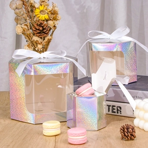 Set of three hexagonal laser kraft paper gift boxes with white ribbons on a wooden table